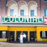 Editorial street portrait for a Bistro on Bridge wedding in downtown Phoenixville in front of the historic Colonial Movie Theatre.