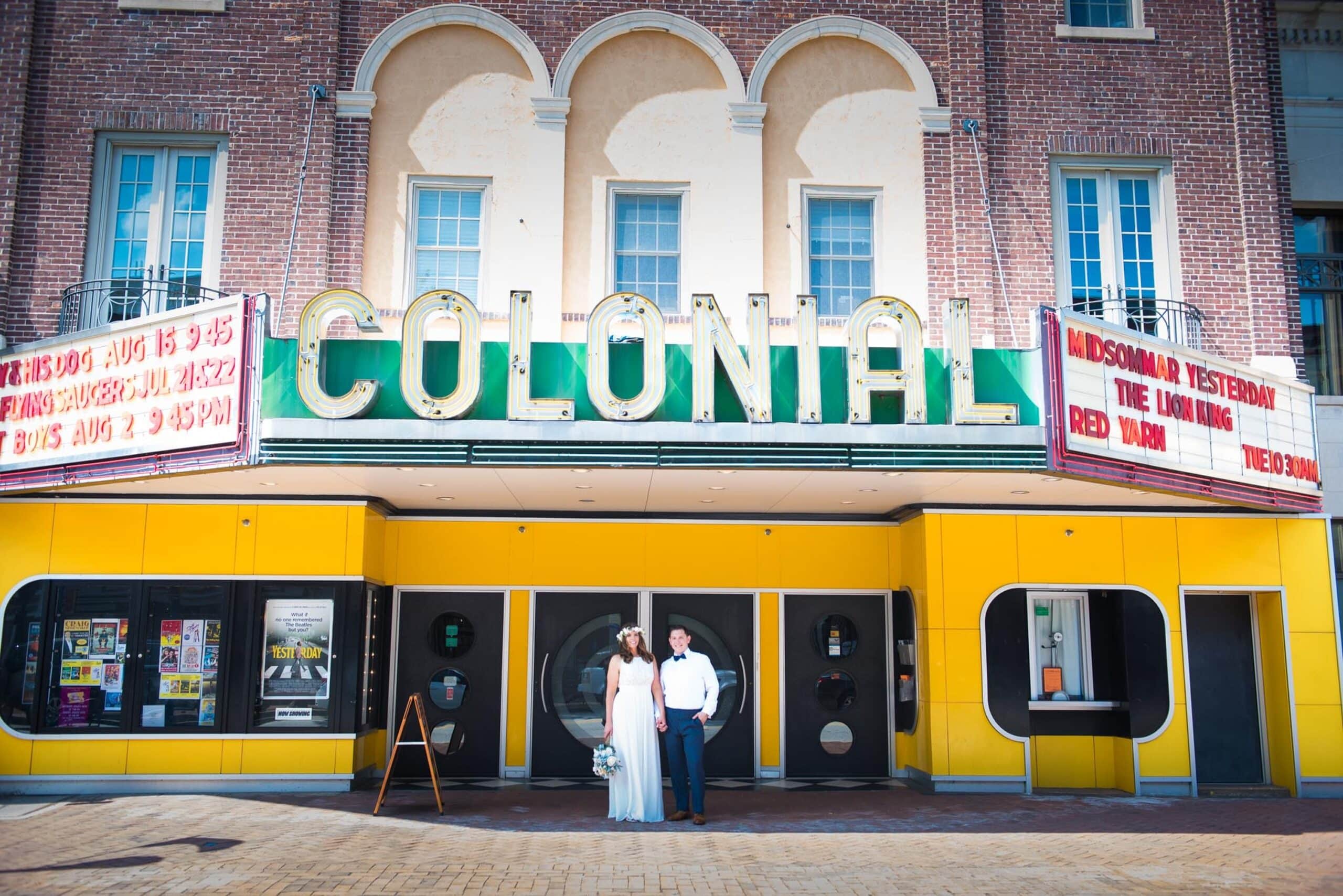 Editorial street portrait for a Bistro on Bridge wedding in downtown Phoenixville in front of the historic Colonial Movie Theatre.